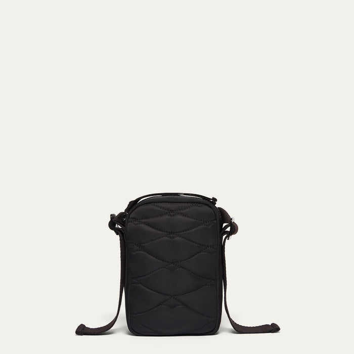 Black quilted crossbody bag on a light beige background