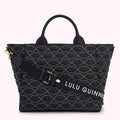 Black quilted tote bag with a white lip pattern and a removable shoulder strap that says "Lulu Guinness".
