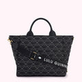 Black quilted tote bag with white lip print and detachable shoulder strap. The strap has the Lulu Guinness logo.