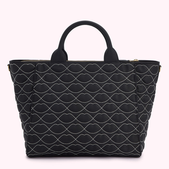 Black quilted tote bag with a lip print.