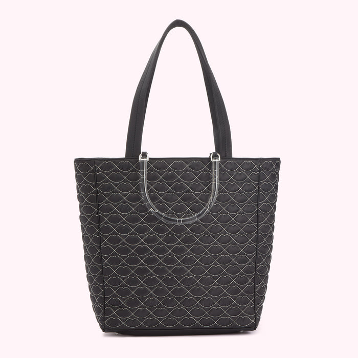 Black quilted tote bag with lip-shaped pattern and clear handles.