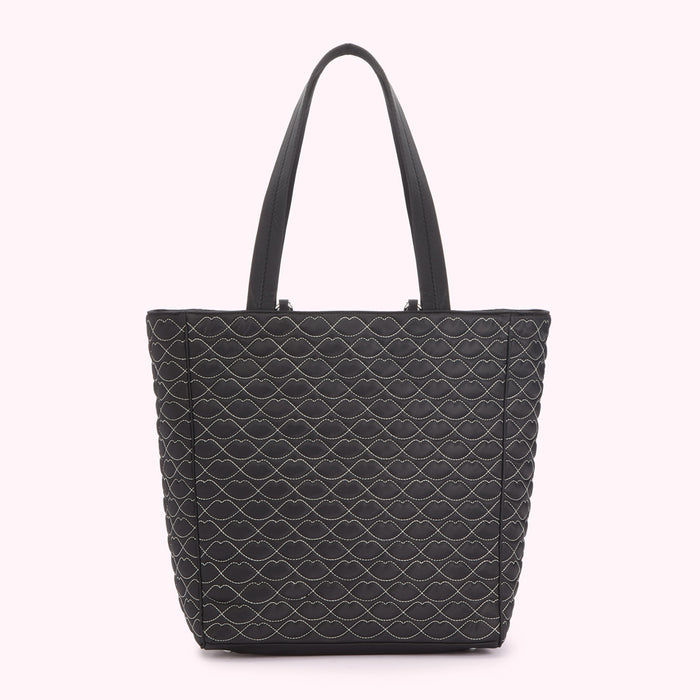 Black quilted tote bag with a lip print pattern.
