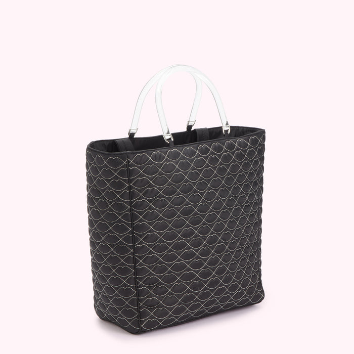 Black quilted tote bag with clear handles and lip print.