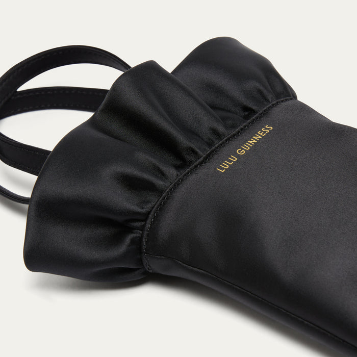 Black satin hand-shaped bag with 'Lulu Guinness' branding on a light gray background