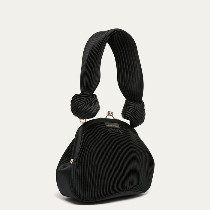 Black pleated satin handbag with a unique handle design on a light gray background
