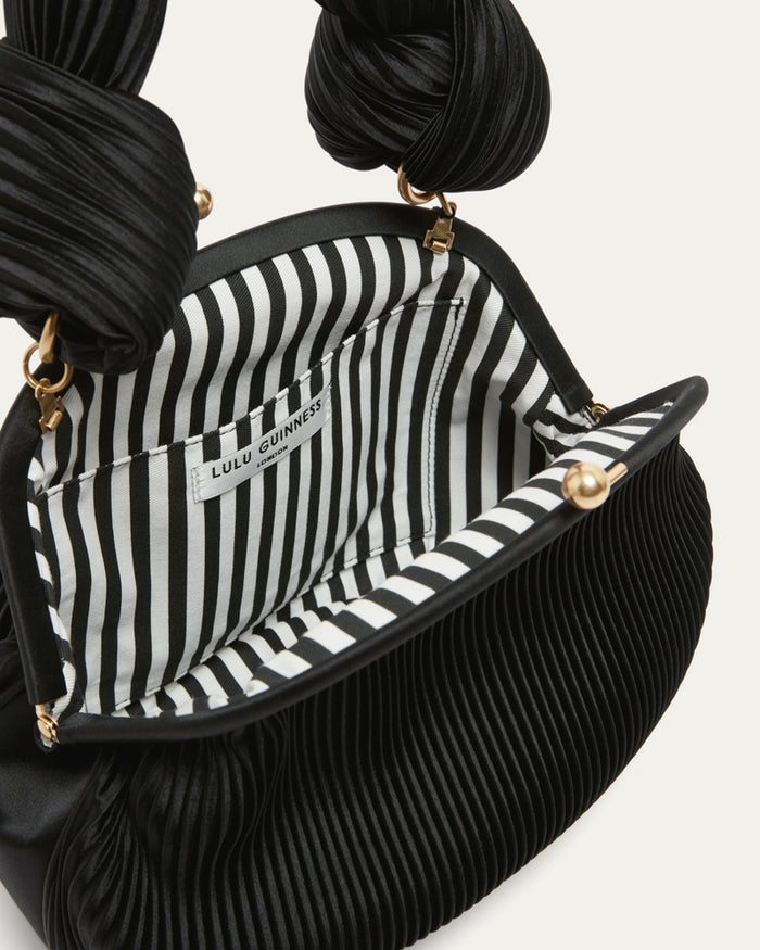 Black and white striped interior of a handbag with 'Lulu Guinness' branding.