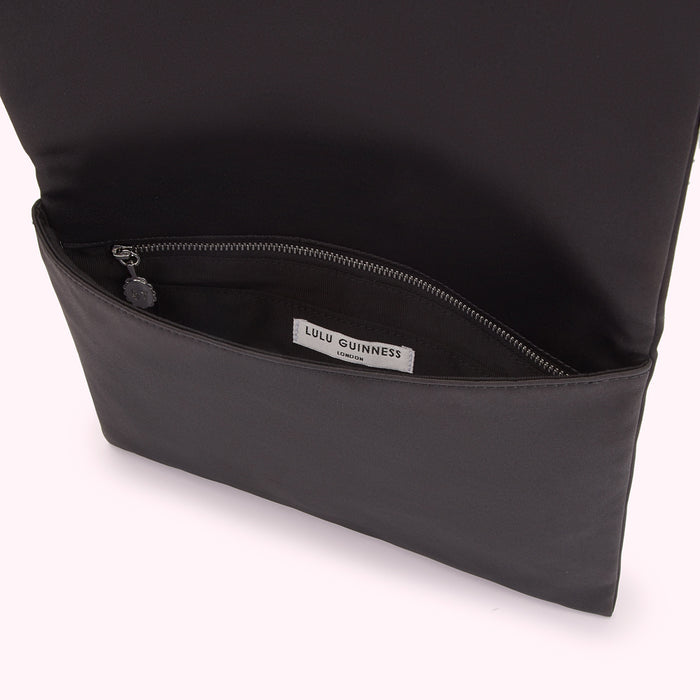 Black Lulu Guinness London clutch opened to reveal interior and zipper.