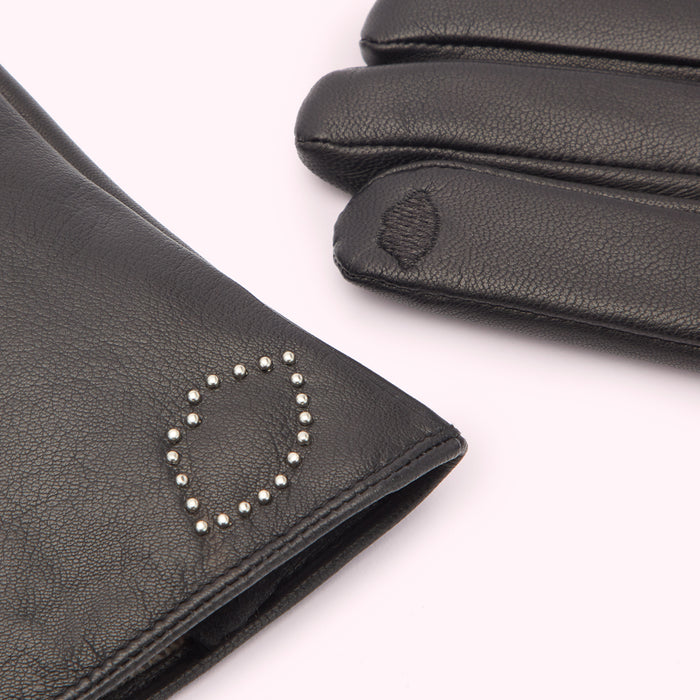Close-up of a pair of black leather gloves, one glove features silver stud detailing.