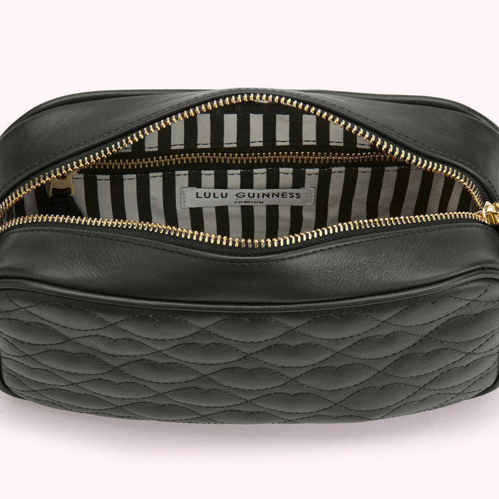 Open black quilted leather Lulu Guinness London crossbody bag with gold zipper and black and white striped interior.