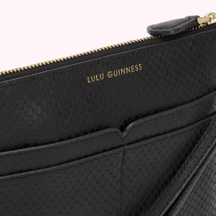 Close-up of a black Lulu Guinness snakeskin-textured pouch with gold zipper and branding.