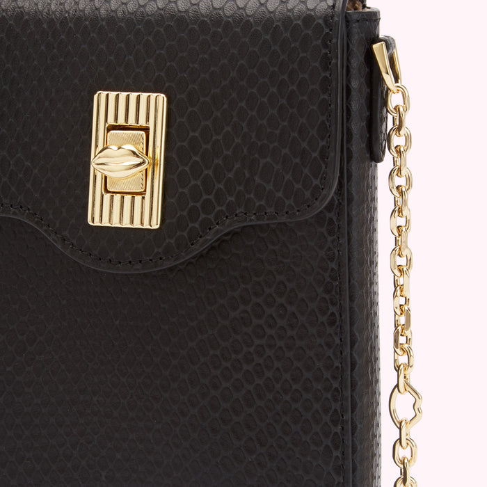 Close-up of a black snakeskin-textured crossbody bag with a gold lip-shaped clasp and chain strap.