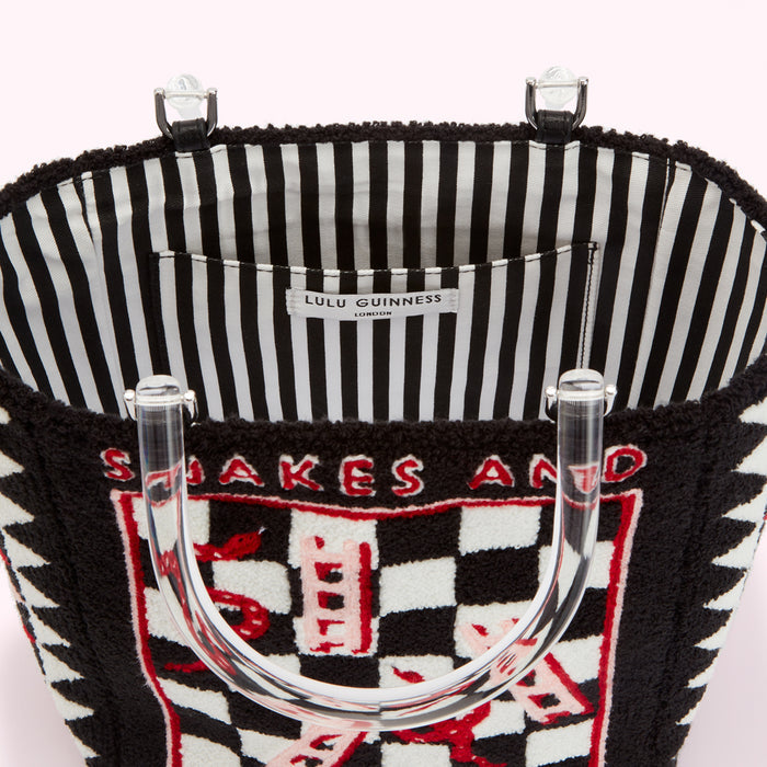 Inside view of a black Lulu Guinness Snakes and Ladders tote bag with clear Perspex handles and a black and white striped lining.