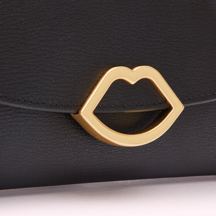 Close-up of a black leather wallet with a gold lip-shaped clasp.