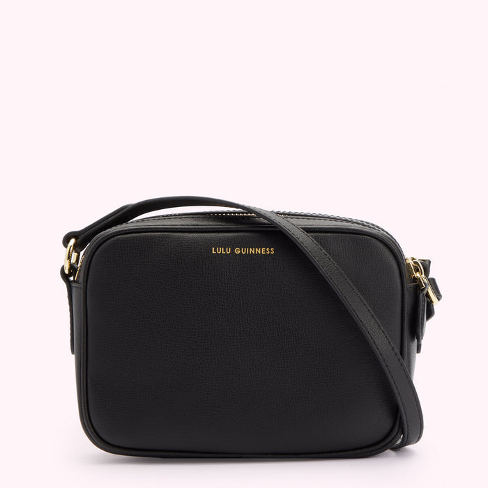 Image of back of black leather crossbody bag with strap folded across. Showing a gold foil print Lulu Guinness logo.