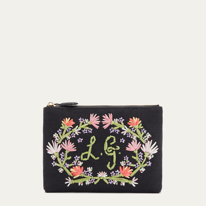 Front image of a black canvas pouch with pastel floral embroidered detail and embroidered L.G. monogram.