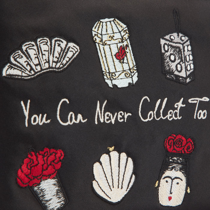 Black fabric with embroidered images of a fan, birdcage, dice, flowers, seashell, and Frida Kahlo, and the text "You Can Never Collect Too".