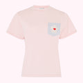 Pink t-shirt with a grey pocket and a flower appliqué©.