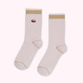 Pair of pale pink socks with gold trim and a small red lip design.