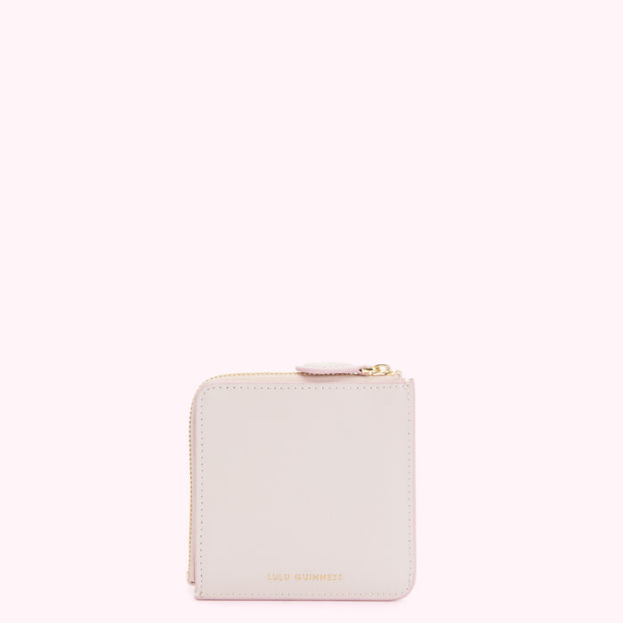 Pale pink Lulu Guinness zip-around purse against a white background.