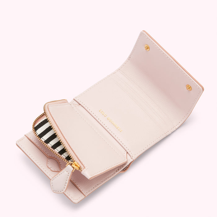 Open light pink leather wallet with a black and white striped zipper.