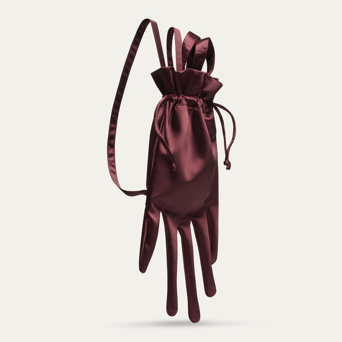 Maroon satin hand-shaped backpack with drawstring on a light gray background