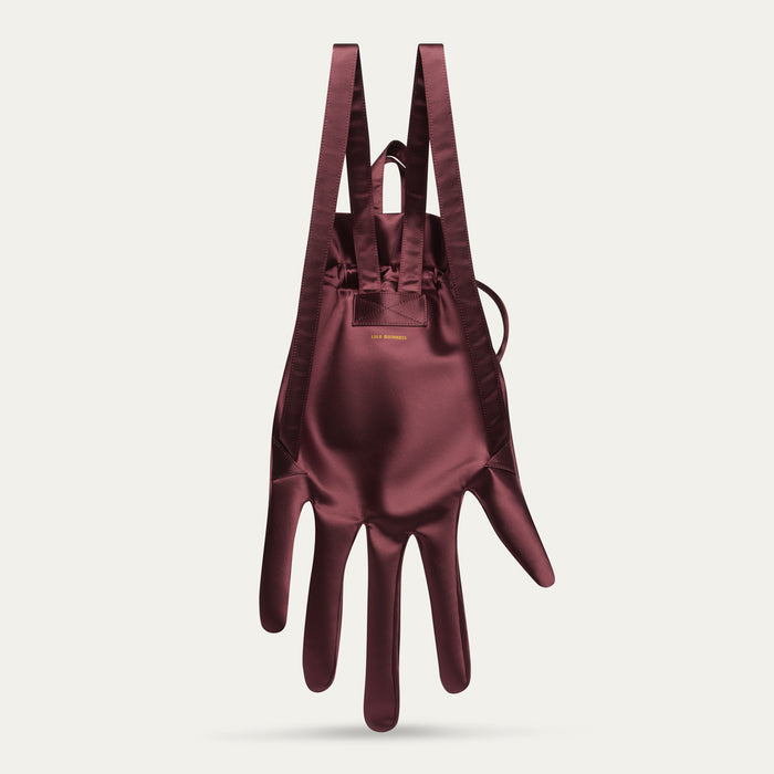 Maroon satin hand-shaped backpack on a light gray background