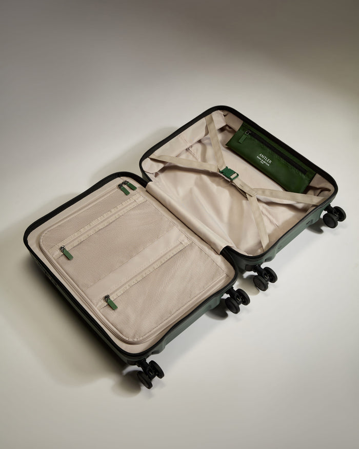 a suitcase with wheels and a green bag