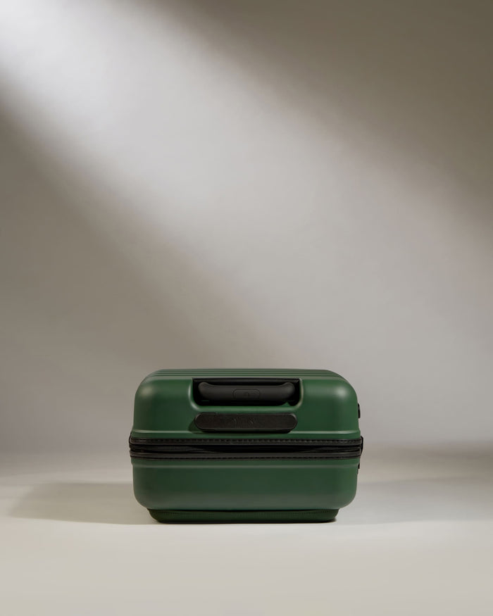 a green suitcase on a white surface