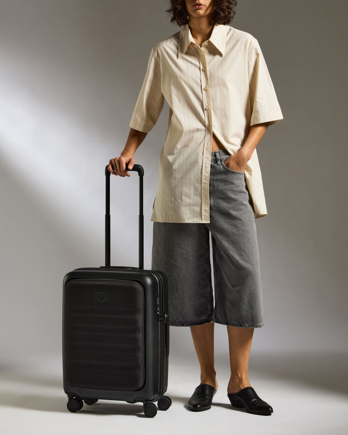 a woman standing with a suitcase