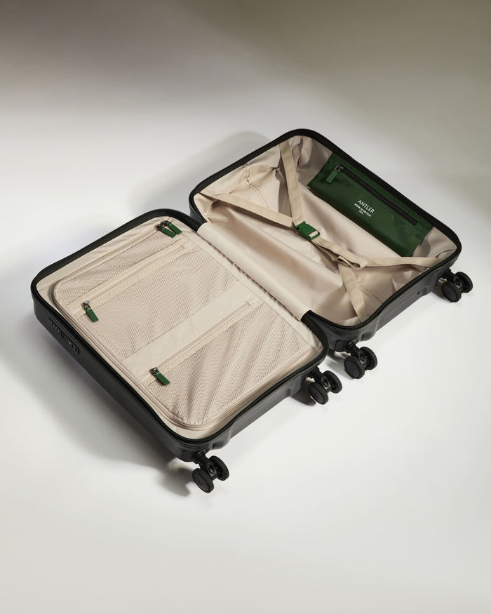 a suitcase with wheels and a green bag
