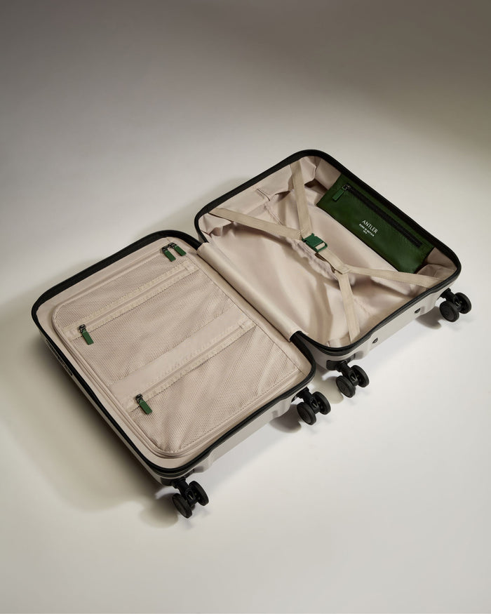 a suitcase with wheels and a green bag