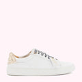 White leather sneakers with gold heel detail and zebra-print laces against a pink background.