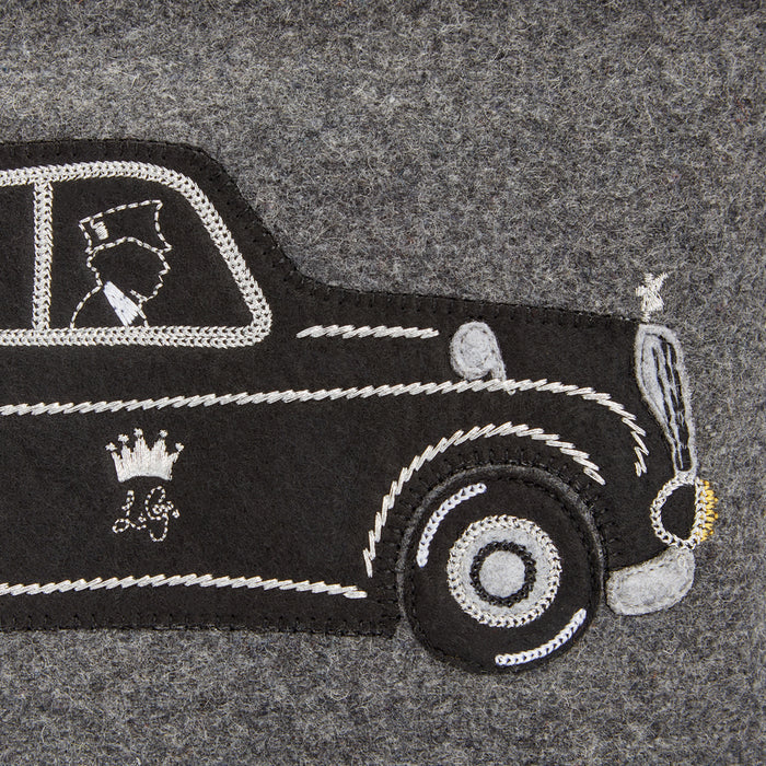 Close-up of embroidered black London taxi cab appliqué© on grey felt.