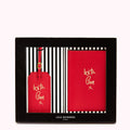 Red Lulu Guinness passport holder and luggage tag gift set in a black box. The items are red leather with gold "With Love x" lettering.