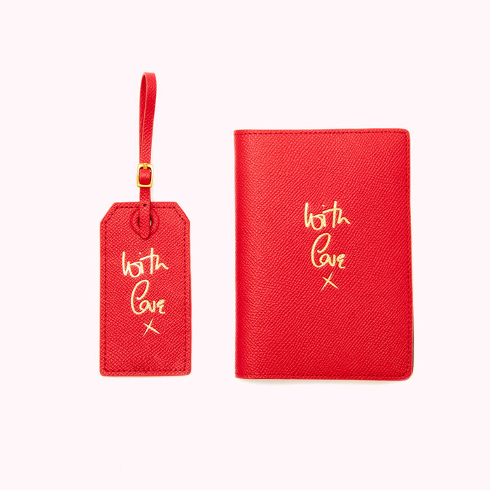 Red leather luggage tag and passport holder with gold lettering that says "with love x" on a white background.