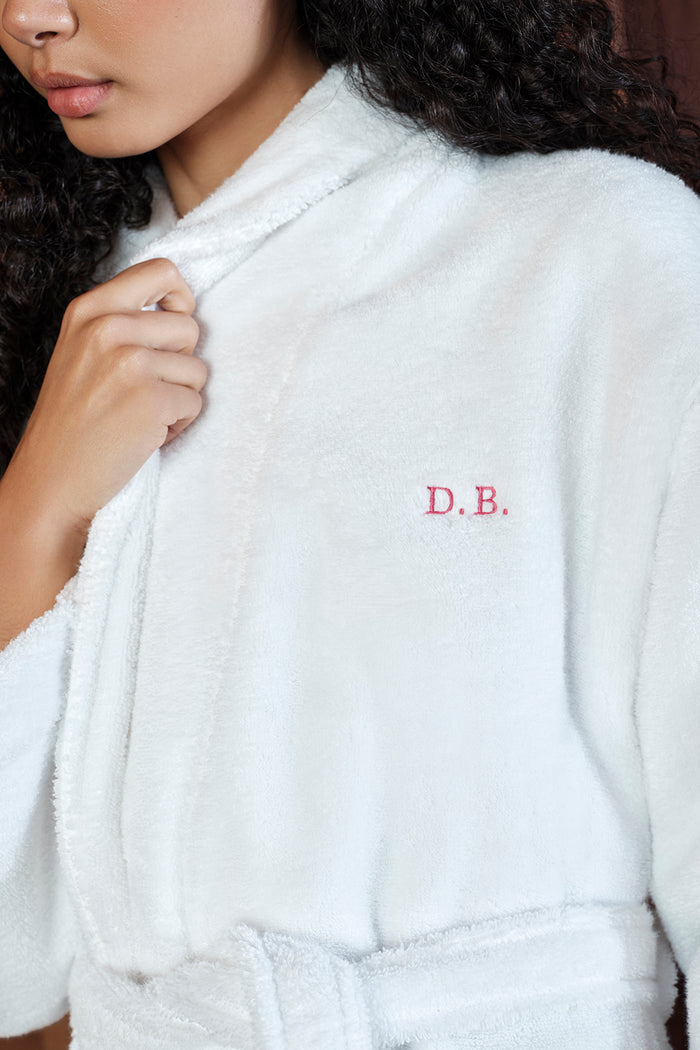 White robe with 'D.B.' embroidery held by a person
|M1