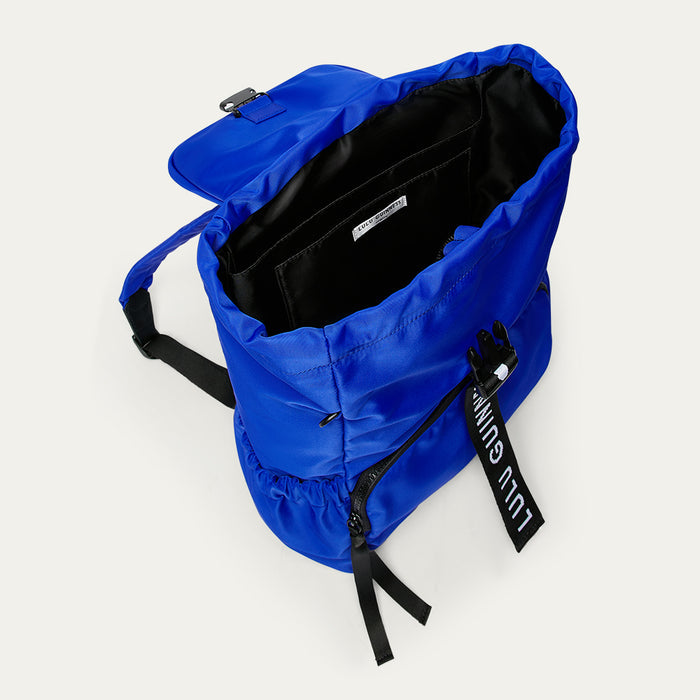 Cobalt blue backpack open revealing a black interior on a white background