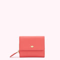 Coral pink leather wallet with gold lip detail.