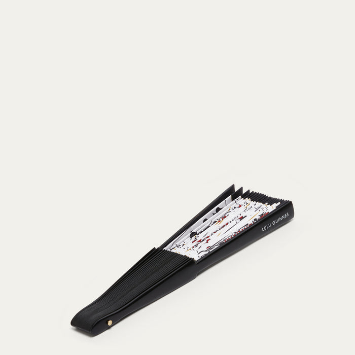 Black handheld fan closed with a deck of cards pattern on a white background