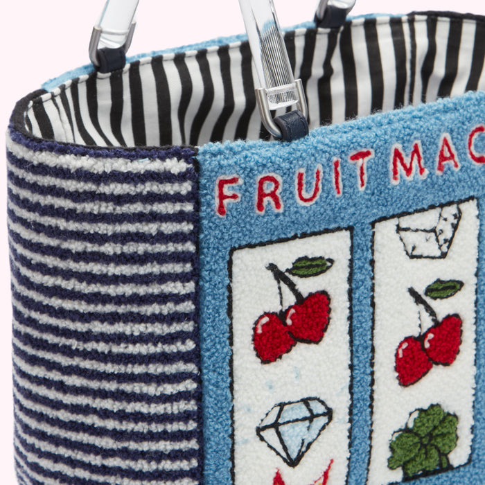 Close-up of a blue and white striped handbag with a fruit machine design.