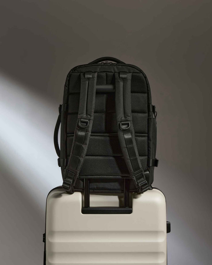 a black backpack on a white suitcase