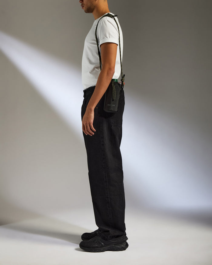 a man standing in a white shirt and black pants
