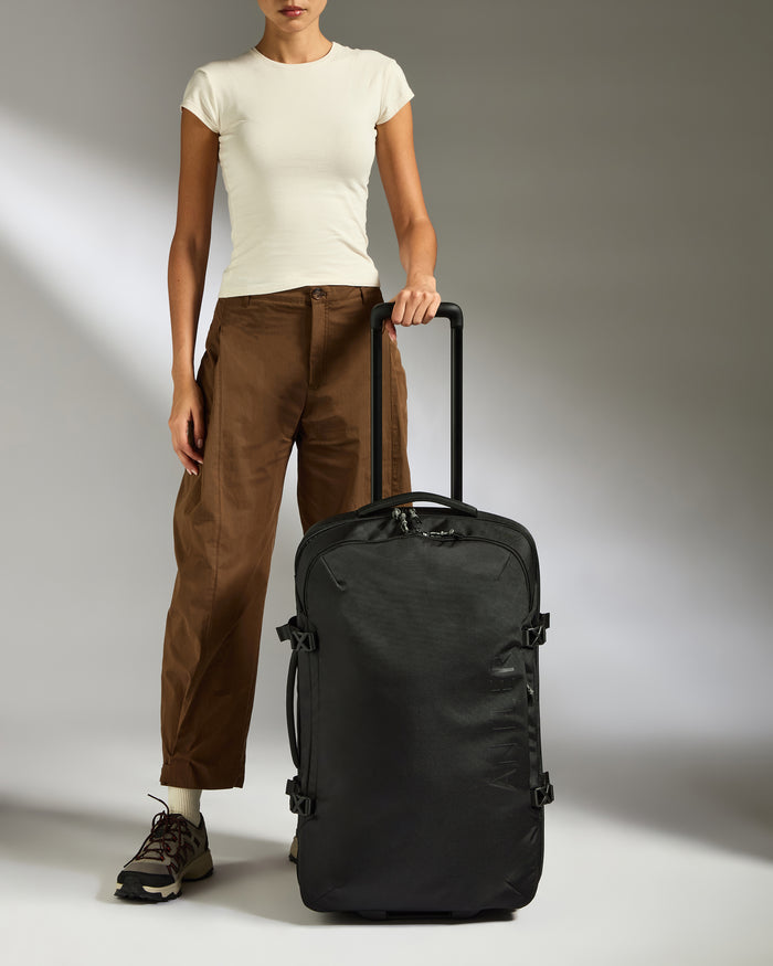 a woman standing next to a suitcase