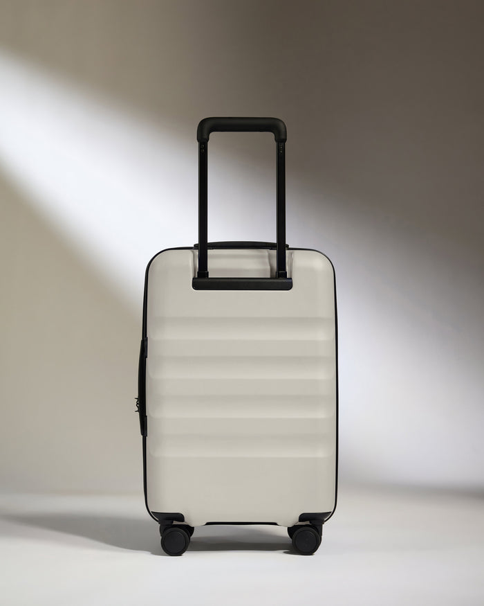 a white suitcase with black handles