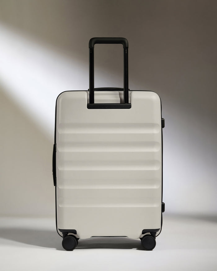 a white suitcase with black wheels