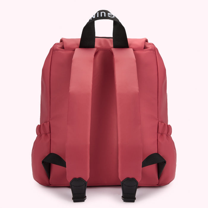 Red backpack with black straps and Lulu Guinness branding.