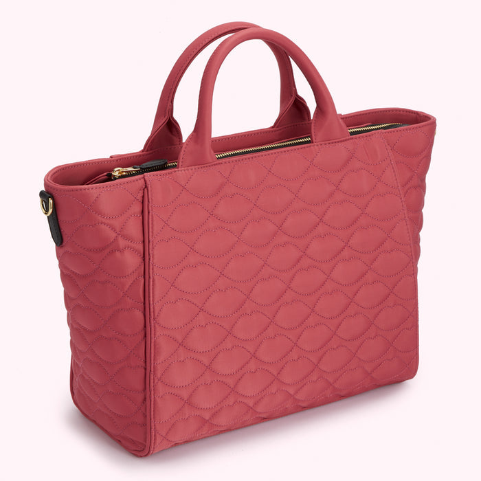 Dusty rose quilted tote bag with black handles and gold zipper.