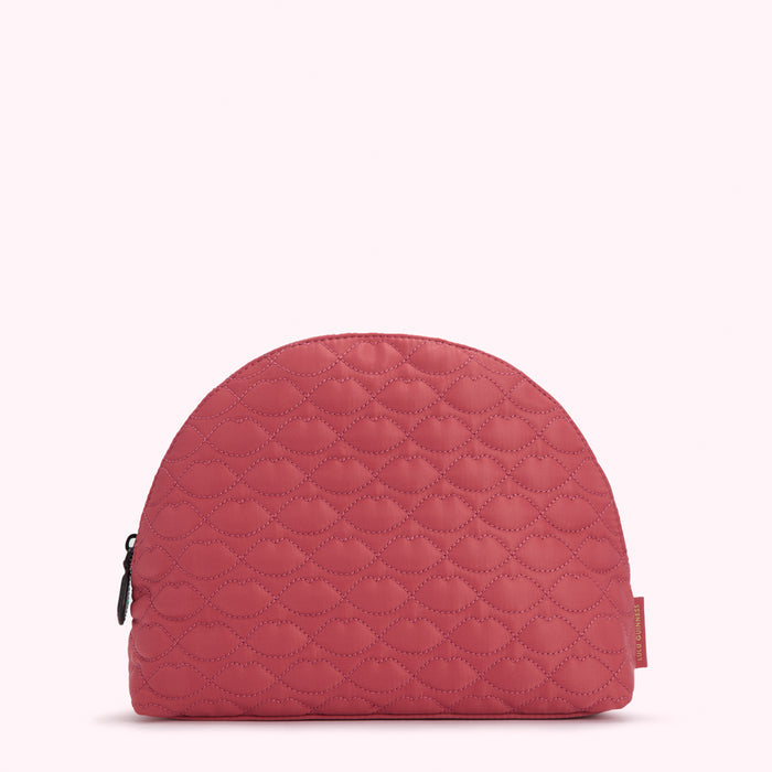 Half-moon shaped quilted cosmetic bag in dusty rose with a lip print.