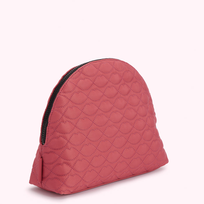 Dusty rose quilted makeup bag with black zipper, featuring a lip print pattern.