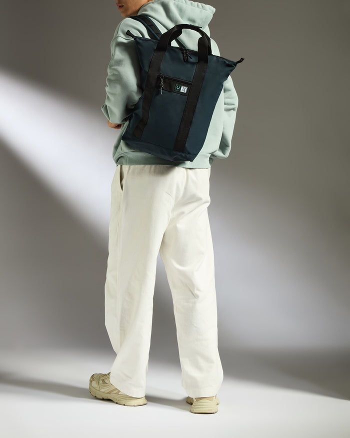 a person wearing a green sweatshirt and white pants